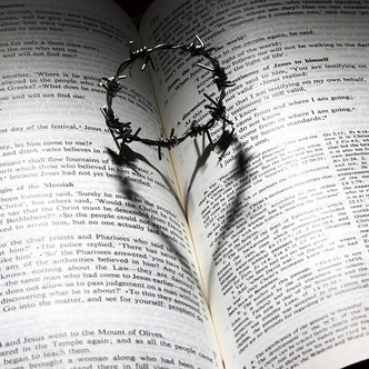 Heart formed from crown of thorns on page