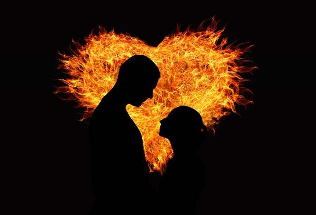 Man and woman in front of fiery heart